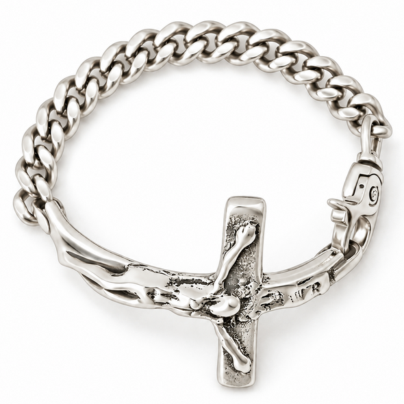 A silver-toned metal bracelet featuring a detailed crucifix pendant with a textured cross and figure, set against a plain white background.