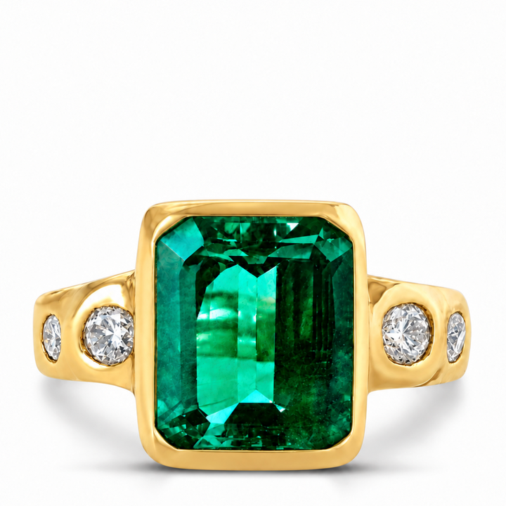 A yellow gold ring featuring a large rectangular emerald-cut green gemstone in a bezel setting, flanked by two small round-cut clear stones on each shank, shown on a plain white background.