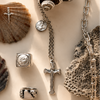 Collection of silver jewelry and shells on a light background