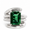 A silver wrap-style ring featuring a large rectangular emerald-cut green gemstone in a four-prong setting, photographed on a clean white background.