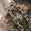 Silver chain necklace on a textured stone surface