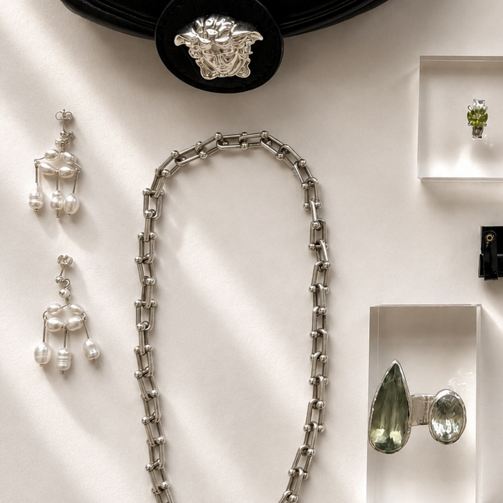 Jewelry including a necklace, earrings, and rings displayed on a white surface.