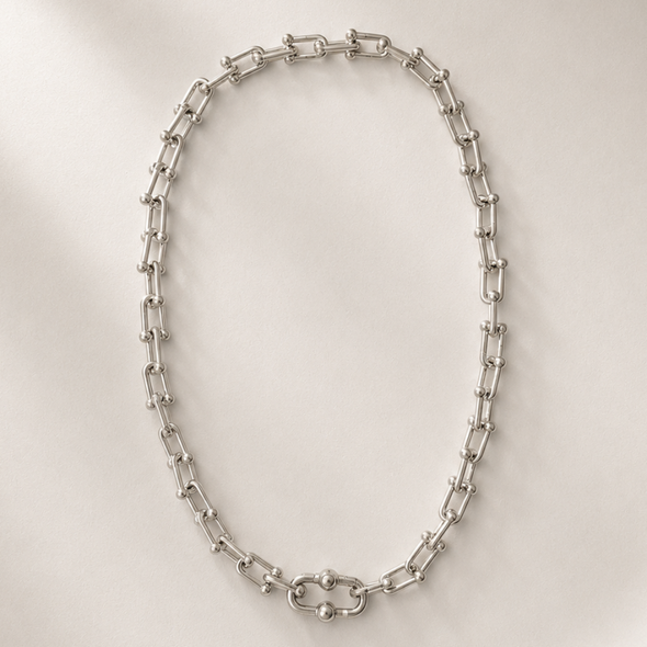 Silver chain necklace on a white plate
