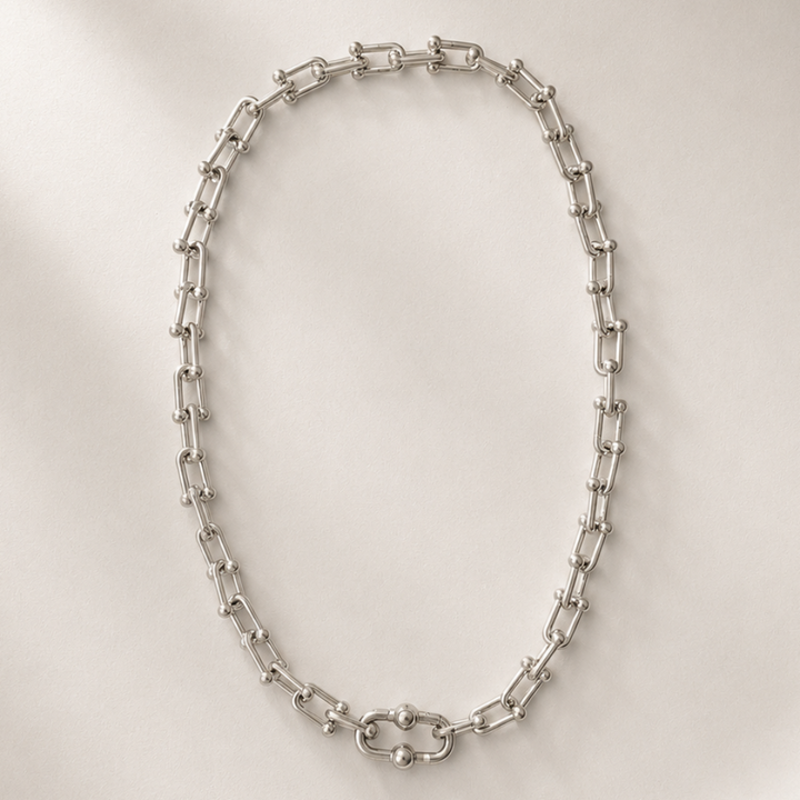 Silver chain necklace on a white plate