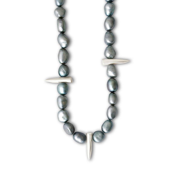 Necklace with gray beads and silver spike-like elements on a white background