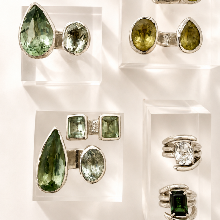 Jewelry display with green gemstone rings and earrings on a white background