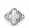 A silver signet ring featuring a large, irregularly shaped white mother-of-pearl cross-shaped centerpiece, set against a clean white background.