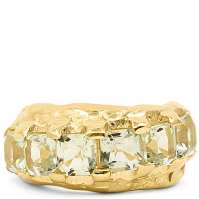 Gold ring with a large gemstone channel on a white background