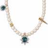 A pearl necklace featuring a central silver starburst pendant with a deep blue gemstone, a gold accent bead, a gold spike charm, and a smaller blue gemstone pendant on the side, set against a plain white background.