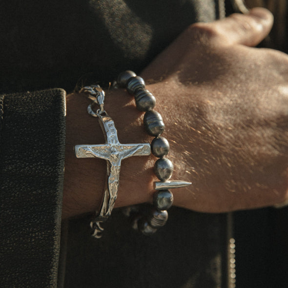close up shot of hands wearing our xxxl crucifix bracelet