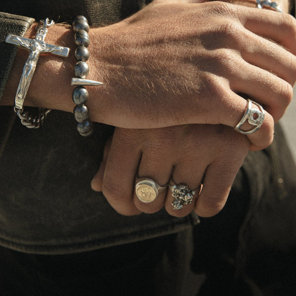hand wearing our oval signet ring cast with 14k yellow gold holy coin