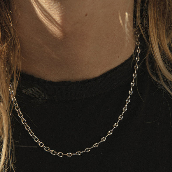close up shot of our half & half chain necklace, being worn by model