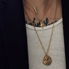 close up shot of model's neck wearing our momento mori coin necklace in gold