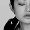 female model wearing our crucifix dagger threader earring in silver. picture with black and white filter