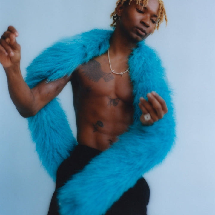 male model posing in blue background holding our mongolian lamb boa