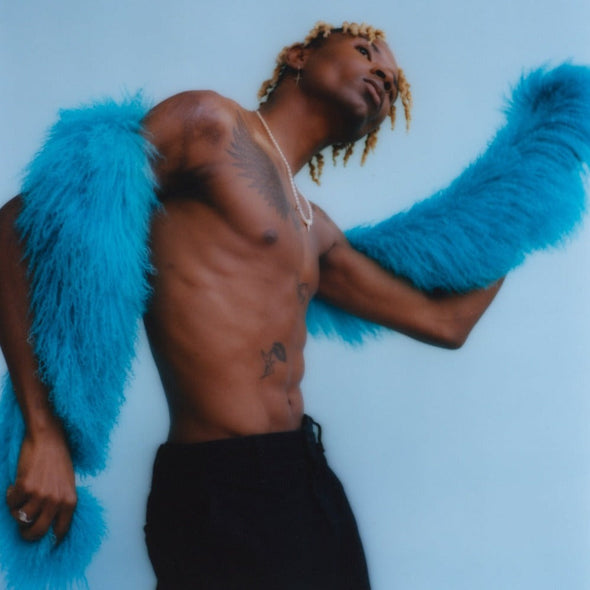 male model posing in blue background holding our mongolian lamb boa in blue