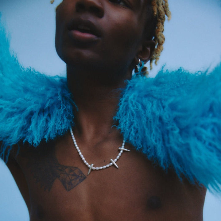 male model posing in blue background holding our mongolian lamb boa in blue