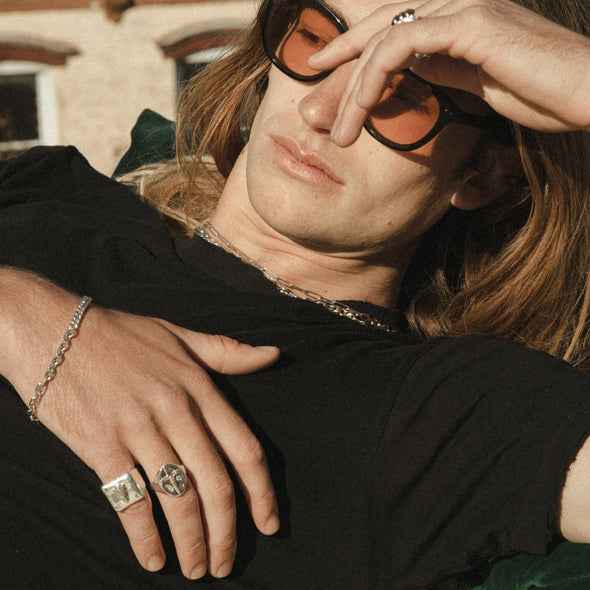 male model laying down, wearing our half & half chain bracelet