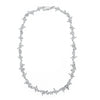 Silver necklace with barbed wire shape laid over white background