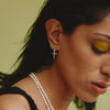 female model wearing our crucifix dagger stud earrings in sterling silver