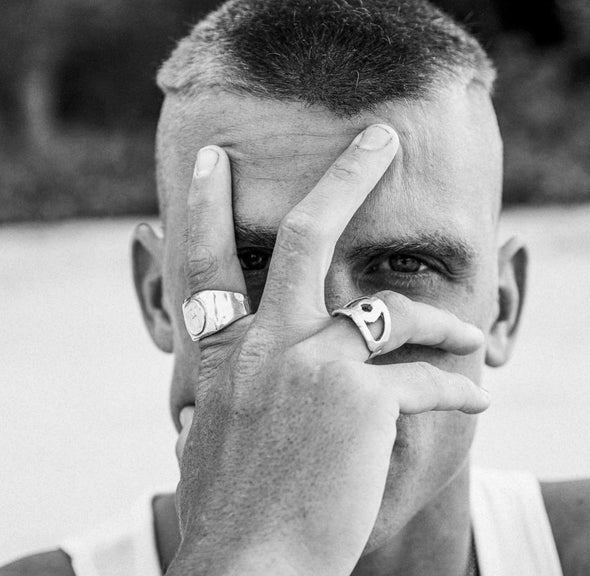 male model wearing our eye cut out ring with his hand covering his face 