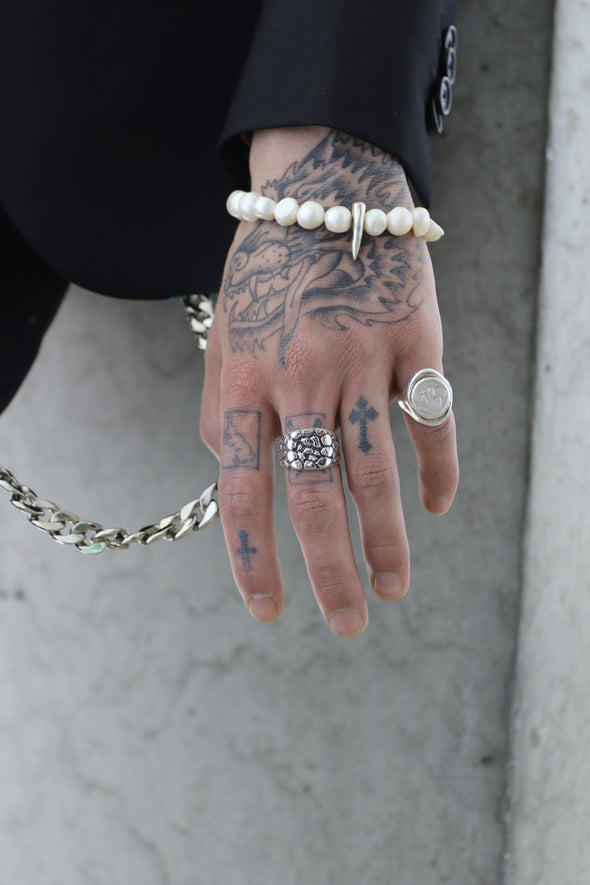 close up shot of hand with our holy signet ring worn on pinky finger
