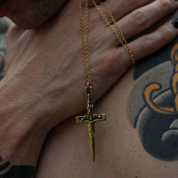 close up shot of hands holding our xl crucifix dagger necklace